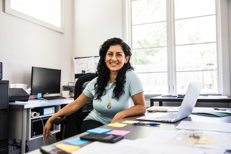 woman in office smiling into camera